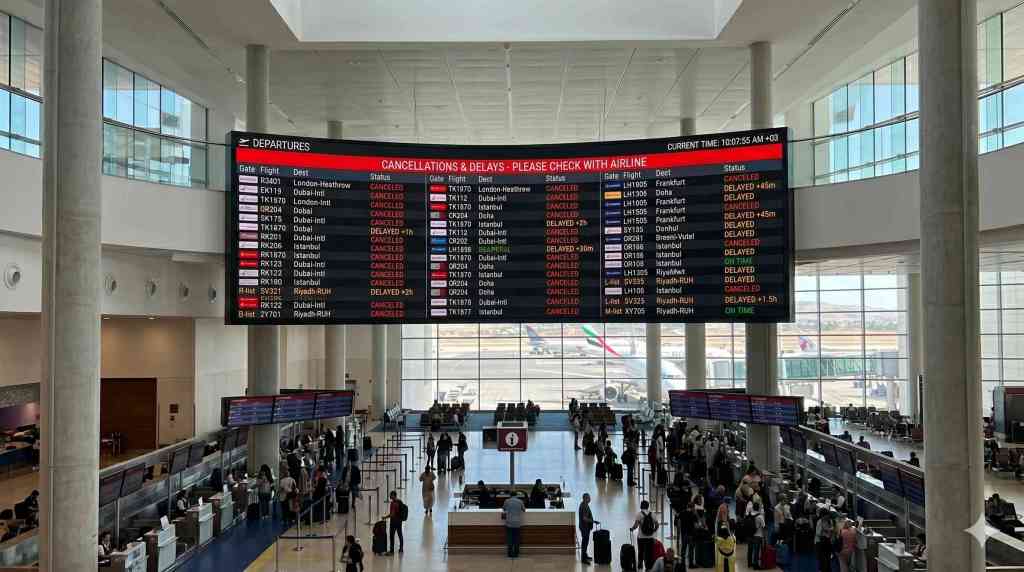 Travel manager using a business travel solution to monitor and rebook flights during a disruption
